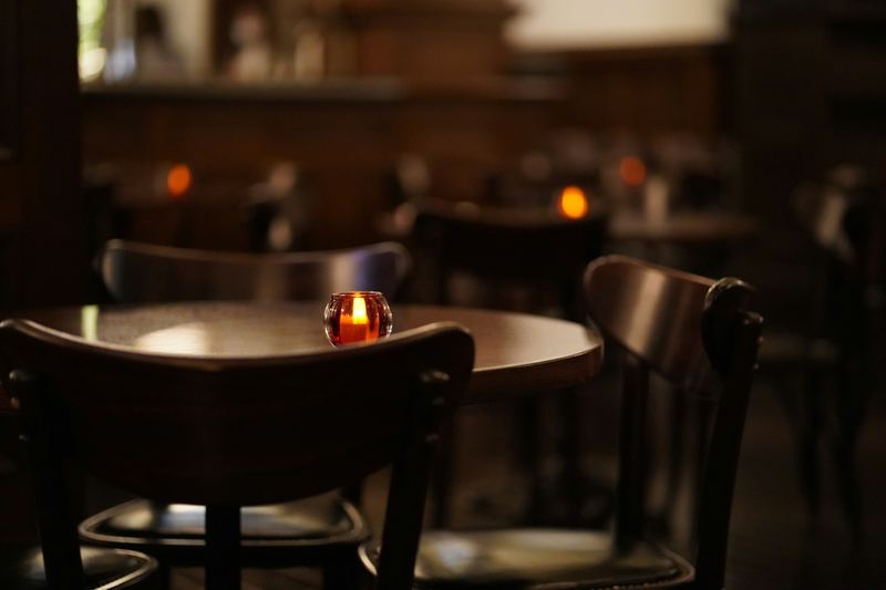 Stolik ze świecą w przyciemnionej sali restauracji