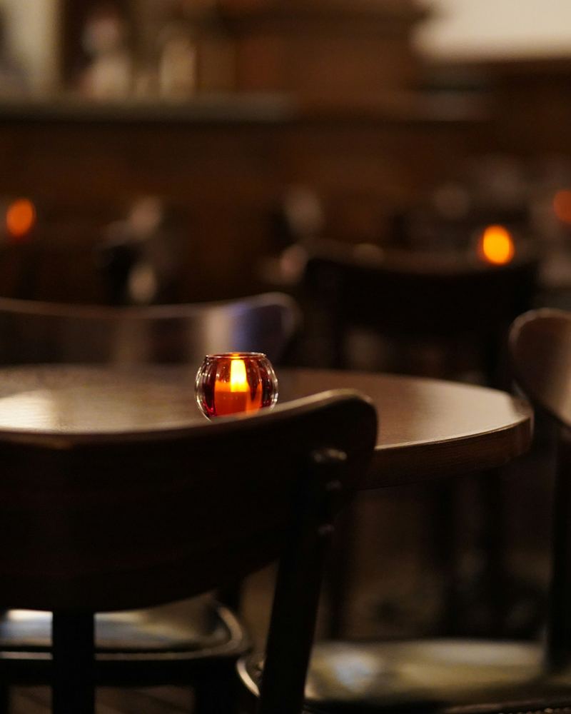 Stolik ze świecą w przyciemnionej sali restauracji